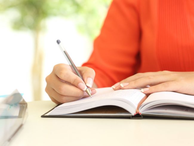 Gastouder houdt uren bij in schrift